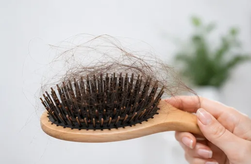 Wooden hairbrush holding a large clump of shed hair